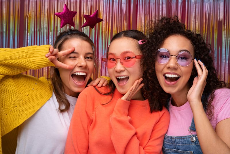 Group of three people posing joyfully outdoors in a park setting, representing the fun and memorable moments captured by R & R Pose at events